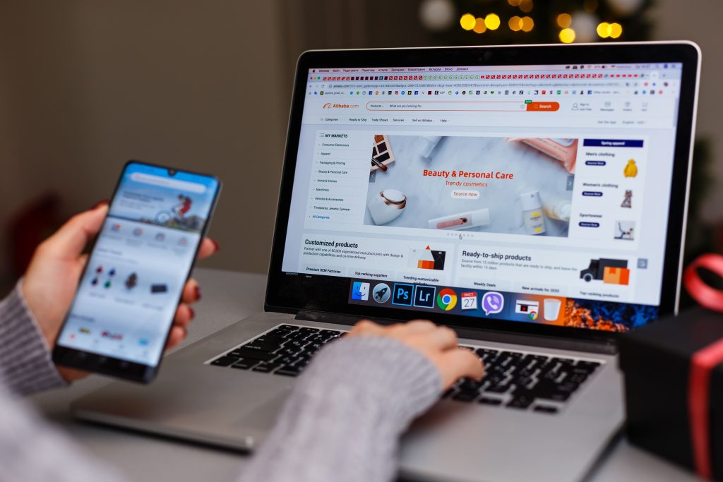 AdobeStock 309972821 Editorial Use Only Personne utilisant un ordinateur et un smartphone pour naviguer sur le web, illustrant l’importance des images optimisées et des balises meta pour le référencement