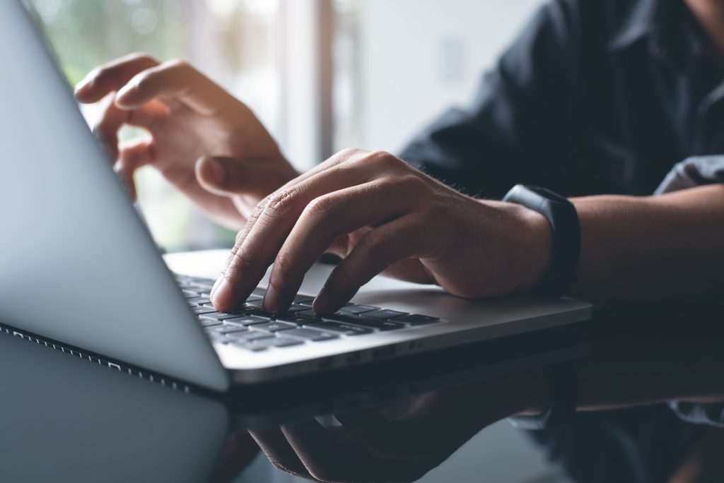 AdobeStock 236629968 Personne tapant sur un ordinateur symbolisant une recherche internet